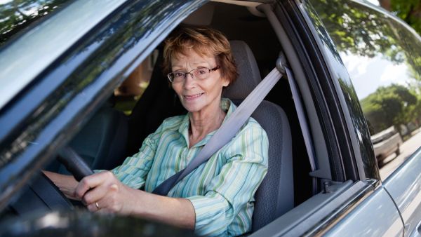 Mulher da terceira idade feliz enquanto dirige carro para idoso