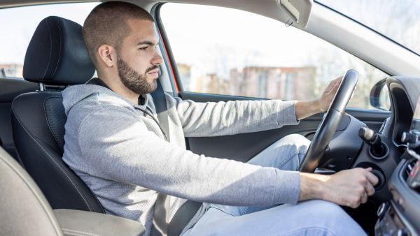 Homem ligando carro para entender o que está por trás da embreagem fazendo barulho