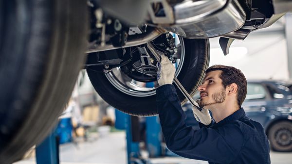 Mecânico fazendo manutenção da suspensão do carro