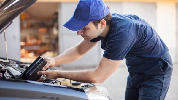 Mecânico fazendo troca de óleo do câmbio automático