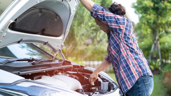 Mulher na estrada tentando identificar onde está o problema de funcionamento de carro automático