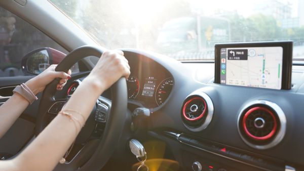 Pessoa com mãos no volante dirigindo para o destino em carro recém comprado