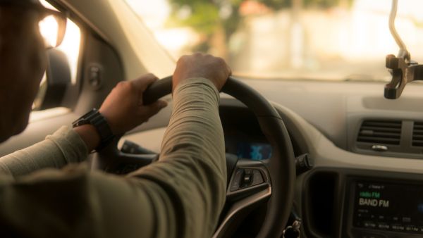 Mulher dirigindo carro automático sem preocupações de volta na subida