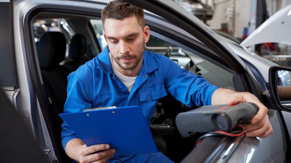 Mecânico avaliando câmbio superaquecido do carro automatico com escaneador automotivo