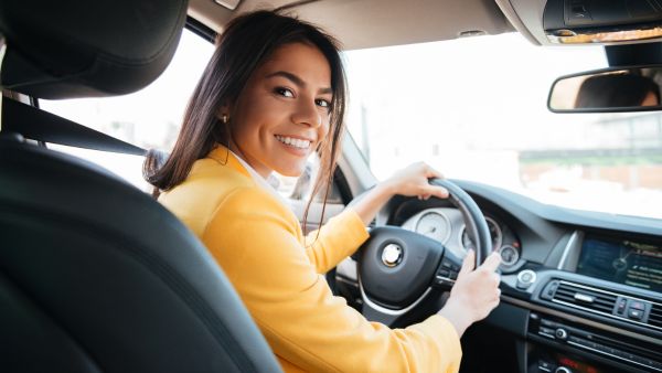 Mulher dirigindo carro automático com as duas mãos no volante
