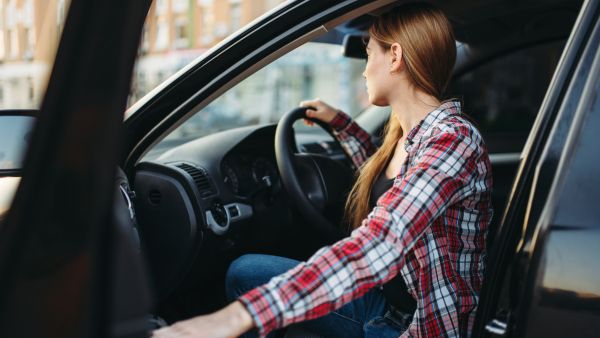 Mulher entrando no carro para começar a dirigir