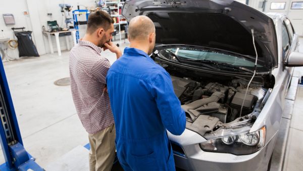 Mecânicos avaliando estado de diferentes componentes do carro