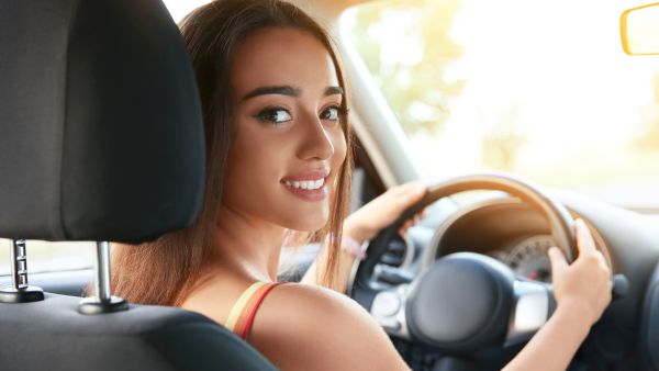 Mulher feliz dirigindo em carro sem embreagem dura ou qualquer outro problema