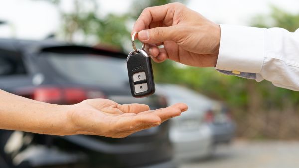 Condutor entregando chave do carro após vendê-lo para outro