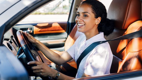 Mulher dirigindo feliz em carro com embreagem em perfeitas condições