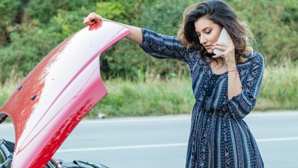 Mulher ligando para seguro após embreagem do carro dar problema