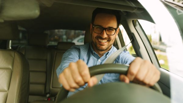 Homem feliz dirigindo um dos modelos de carro mais populares