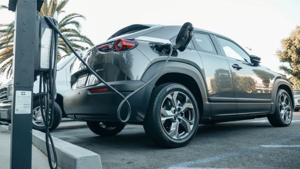 Carro elétrico sendo recarregado em posto