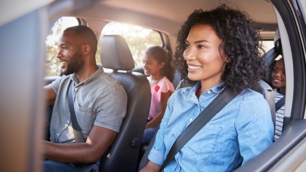 Família feliz indo viajar nas férias de fim de ano de 2024 com carro em bom estado