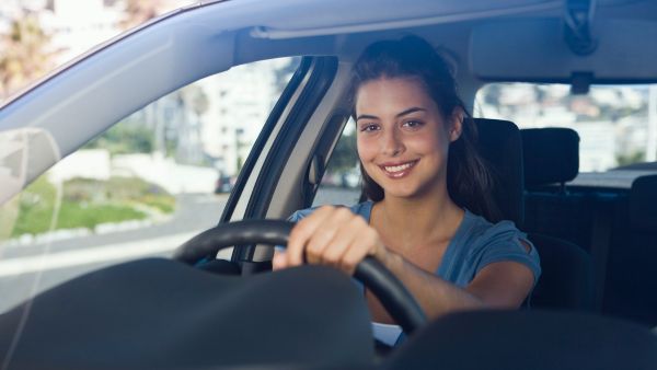 Mulher feliz dirigindo após trocar de carro por modelo novo