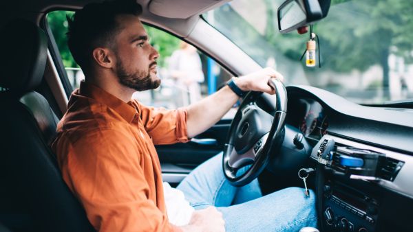 Homem procurando lugar para estacionar após perceber carro engasgando quando acelera
